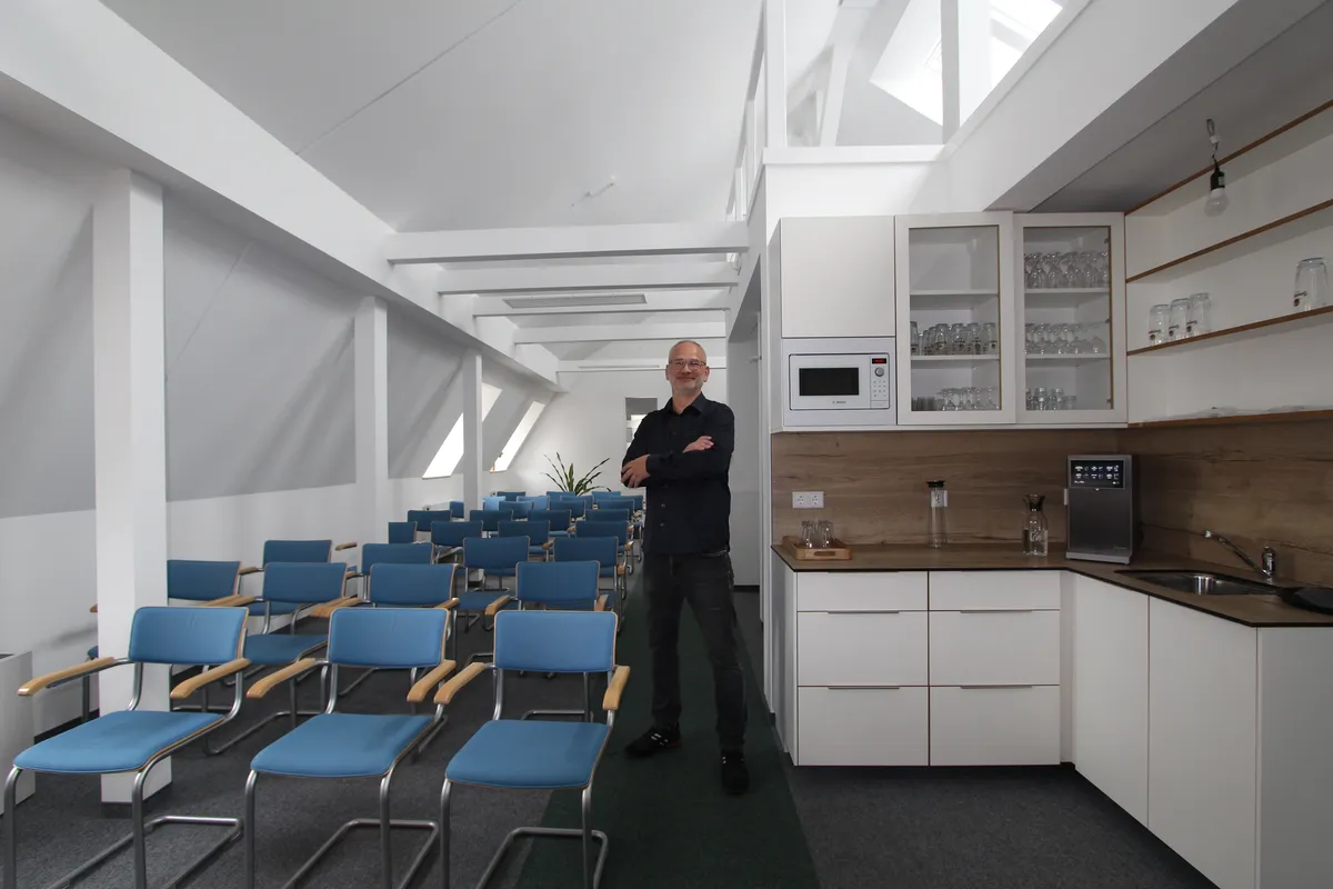 Stefan Ziesecke im hellen Versammlungsraum im Dachgeschoss der HAMKON-Büroräume